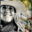 Linnea Martina Hannigan smiling in a wide-brimmed hat, shown in black and white against a colourful abstract artwork background.