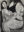 Large charcoal drawing by Laila Pierce showing a seated figure holding their body beside a mirror with a reflected face.