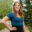 Michelle Neriuoka smiling outdoors on a tree-lined path.