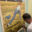 Jamie Morris painting details on a large artwork of a girl running through a wheat field with a train in the background.