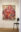 Large figurative painting of a seated figure surrounded by swirling organic forms, installed in a contemporary gallery.