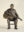 Bronze sculpture of musician Harry Manx seated on a chair playing a slide guitar.