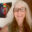Portrait of jewellery artist Melody Armstrong smiling beside one of her colourful abstract artworks.