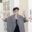 Portrait of artist Anthea Black smiling with both hands raised in a gallery space surrounded by prints and artworks.
