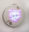 Circular embroidered artwork with a bright LED display showing a purple devil emoji against a lace-patterned textile surface.