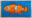 Bright orange clownfish illustration created with acrylic markers in a sketchbook against a vivid blue background.
