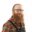 Portrait of Jeff Wielki wearing glasses, a plaid shirt, and a workshop apron against a white background.
