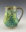 Hand-built stoneware ceramic mug by Gillian Boon with layered green and turquoise glazes, raised organic textures, small sculpted forms and a curved handle.