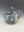 Hand-built stoneware teapot by Gillian Boon with blue-green glazing and raised octopus tentacles wrapping around the rounded body, accented by suction-cup textures.