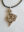 Sculptural silver pendant by Karen Kryzan with an irregular flowing surface formed from a cast wax impression of snow, suspended from a black cord.